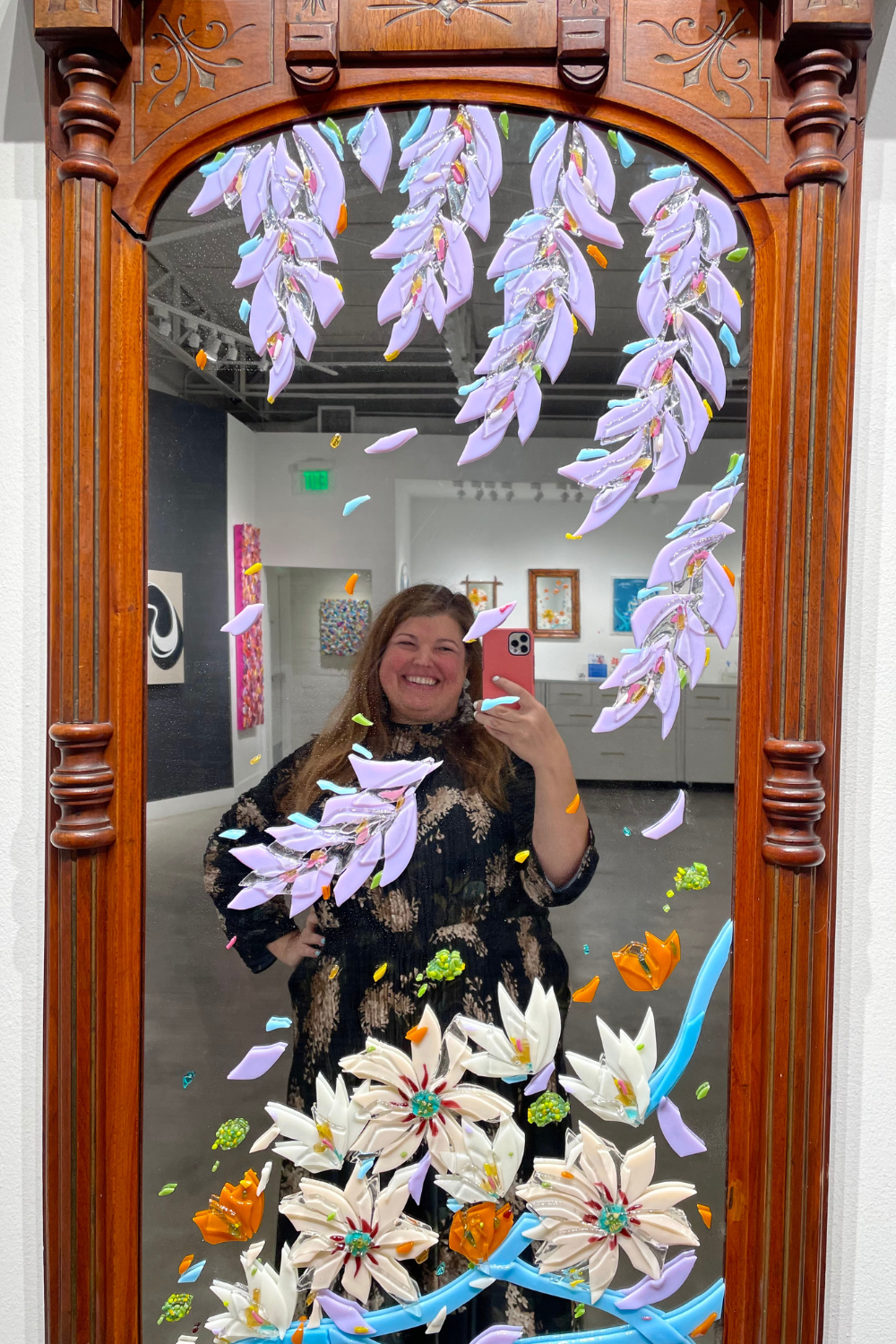 Glass fused flowers on a vintage mirror with Anna Lou Curnes, Glass Artist, reflected in the mirror.